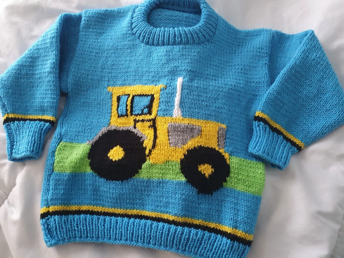 Carol's blue knitted jumper with yellow tractor on the front