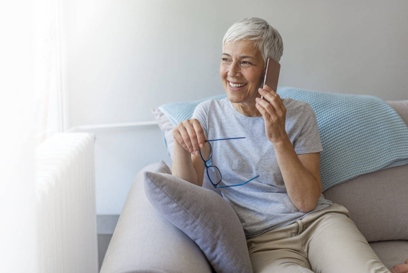 Lady talking on her mobile phone with glasses in the other hand