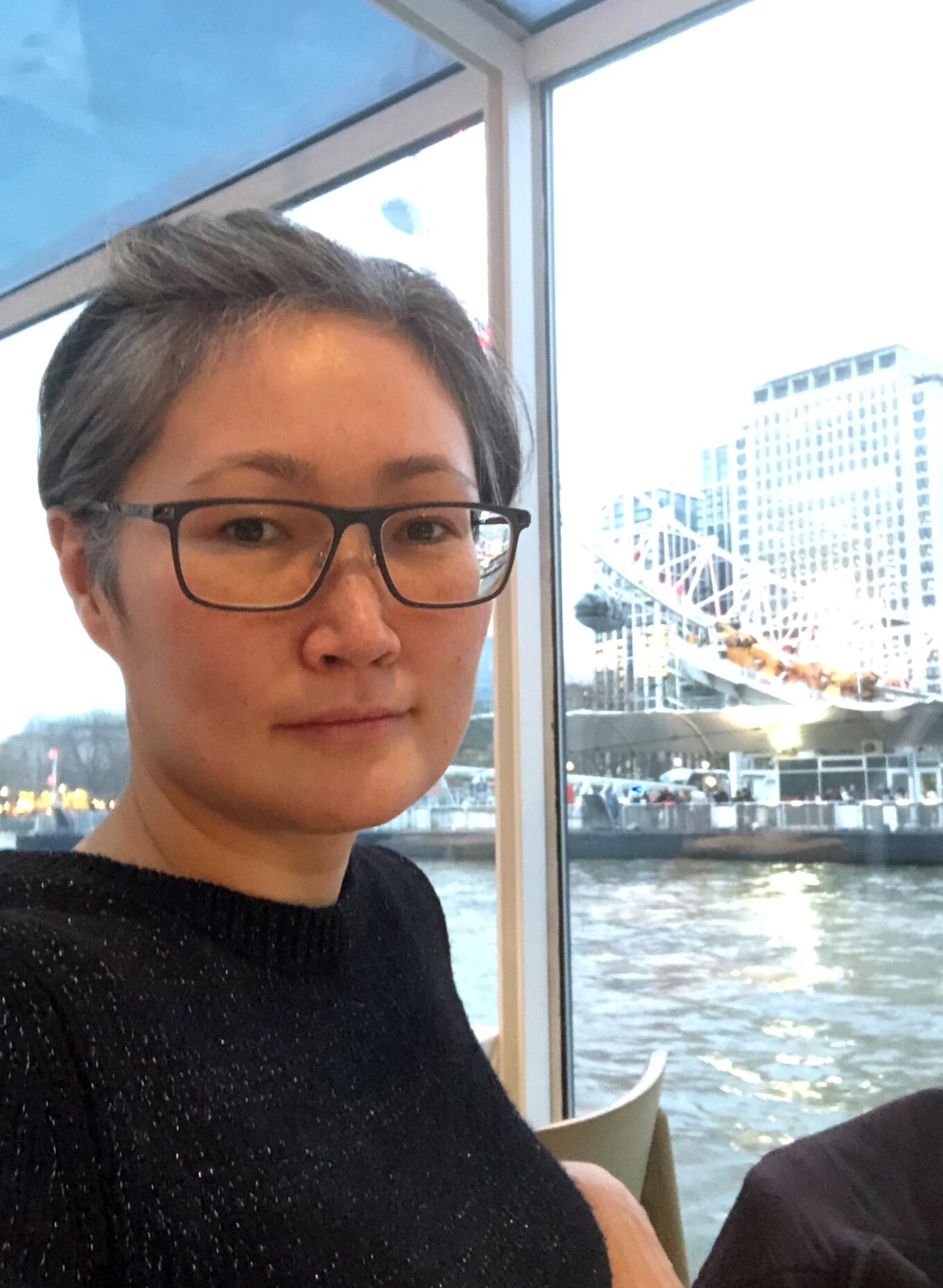 Sightline Volunteer wearing glasses sat on a boat with water in the background