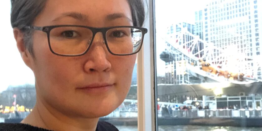 Sightline Volunteer wearing glasses sat on a boat with water in the background