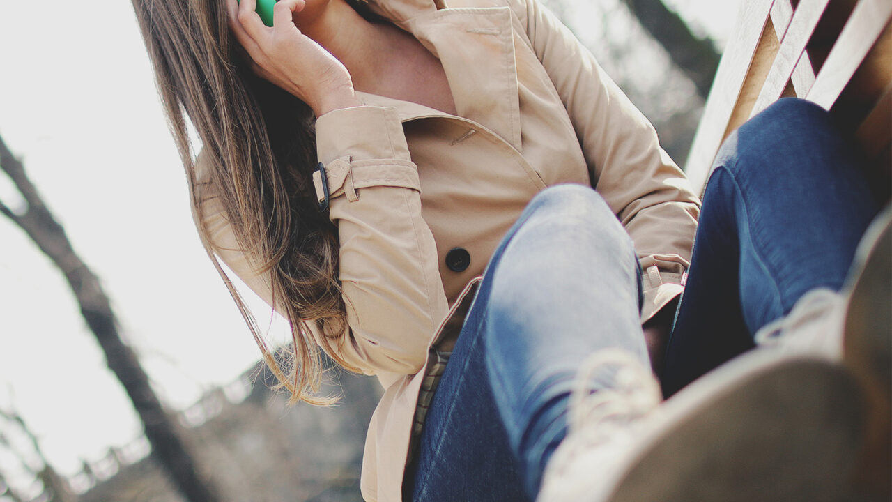 Lady holding a mobile phone up to her ear and smiling