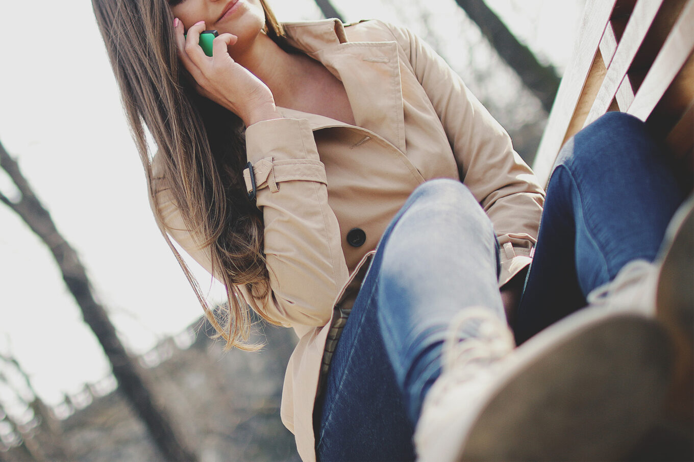 Lady holding a mobile phone up to her ear and smiling