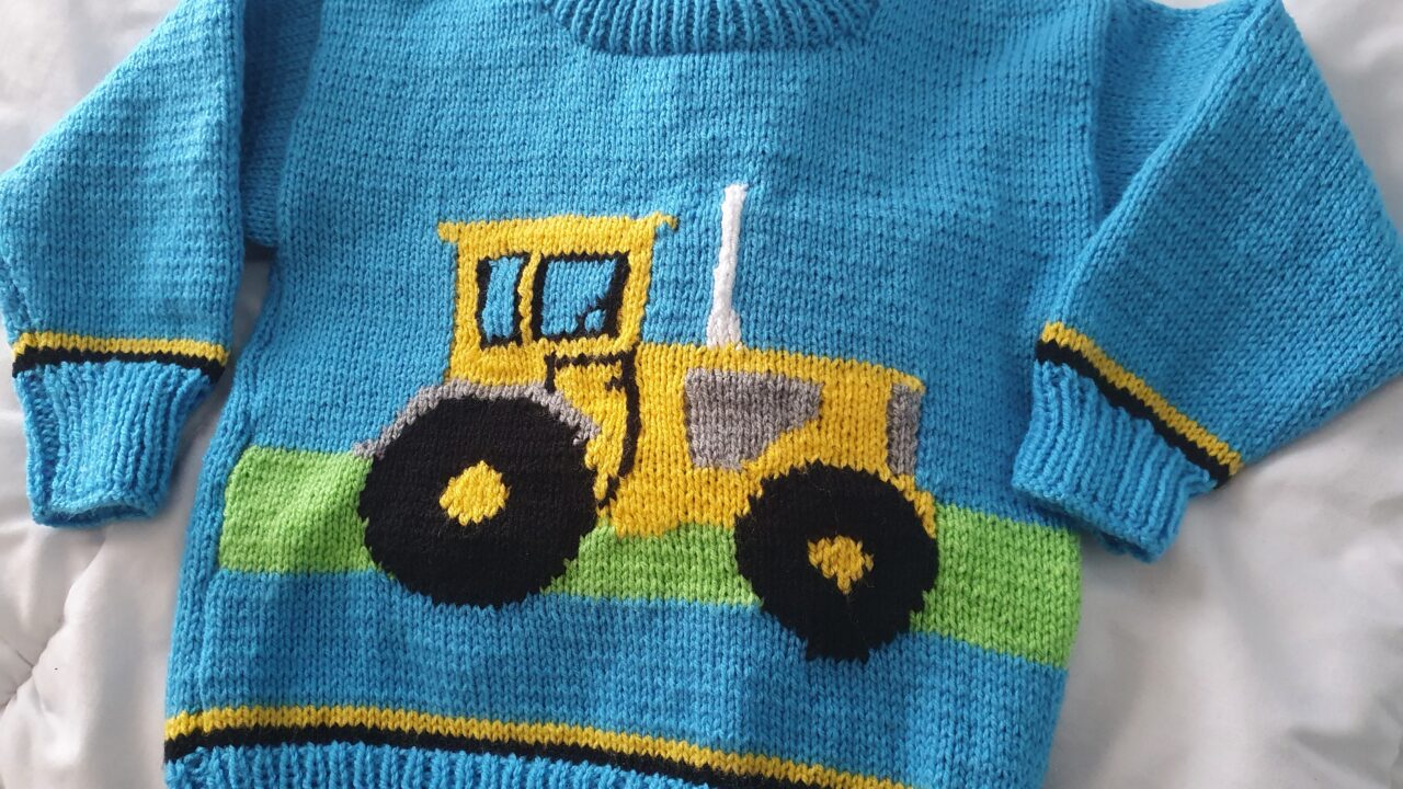 Carol's blue knitted jumper with yellow tractor on the front