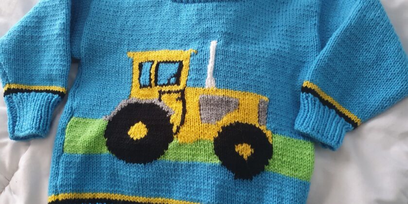 Carol's blue knitted jumper with yellow tractor on the front