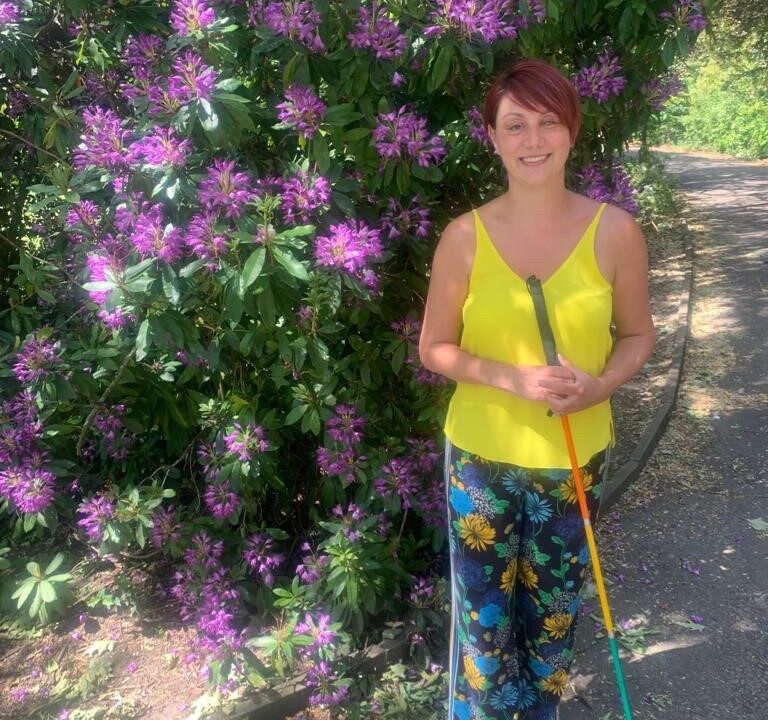 Nina standing in front of purple flowers