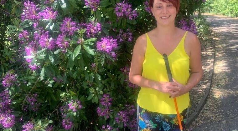 Nina standing in front of purple flowers