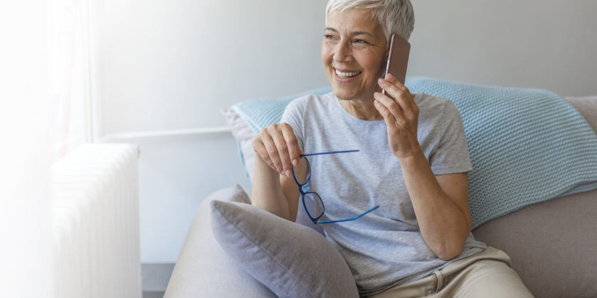 Lady talking on her mobile phone with glasses in the other hand