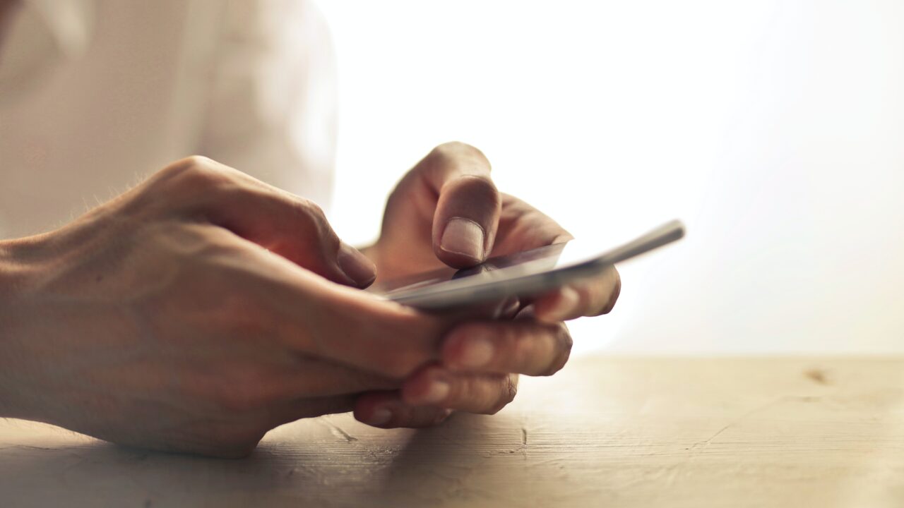 Close up photo of a mobile phone being held.