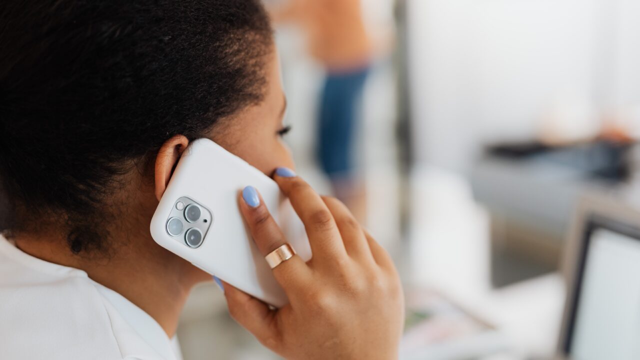 Person holding a mobile phone up to their right ear.