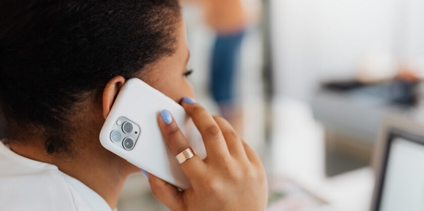 Person holding a mobile phone up to their right ear.