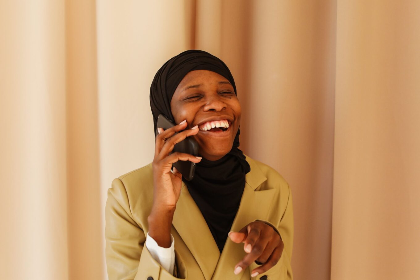 Lady in her twenties laughing whilst on a phone call